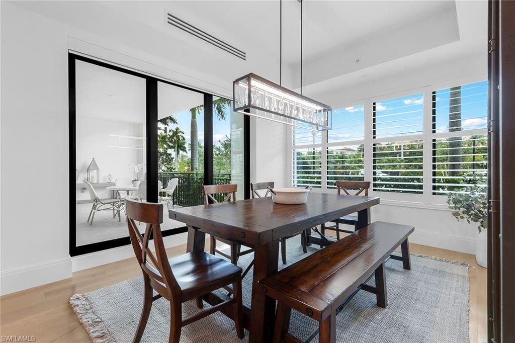 1130 3rd Avenue South, Unit 115 Naples, FL 34102 - Photo 8 of 28 a view of a dining room with furniture large windows and wooden floor