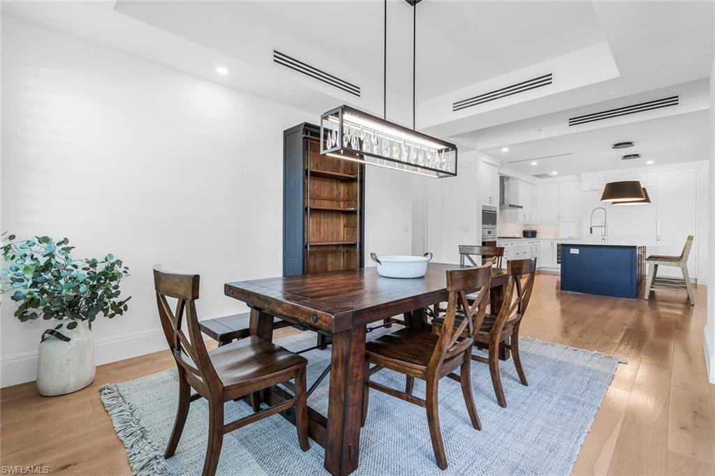 1130 3rd Avenue South, Unit 115 Naples, FL 34102 - Photo 9 of 28 a view of a dining room with furniture and wooden floor