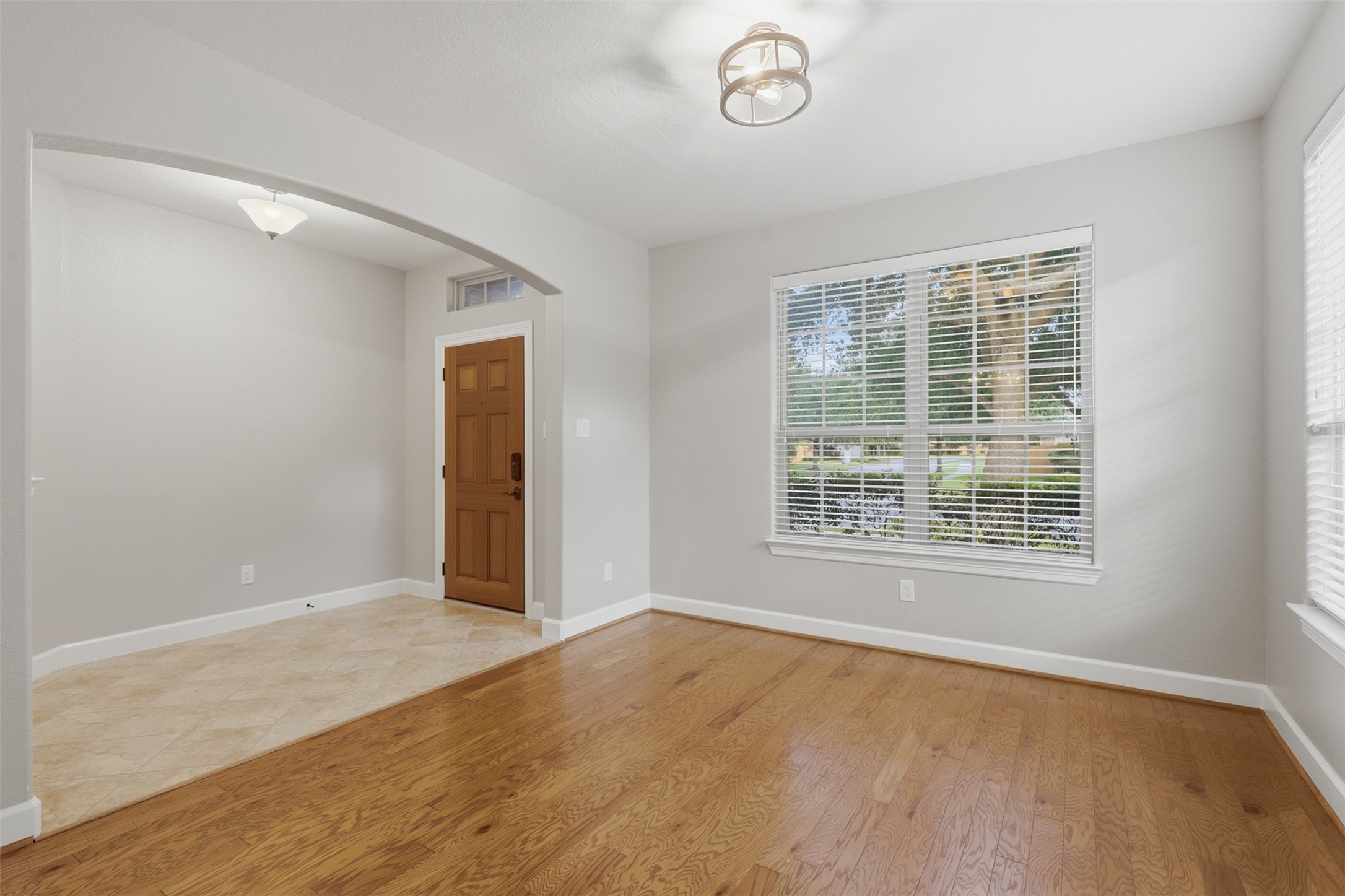 721 Rufina Street League City, TX 77573 - Photo 2 of 33 A gracious formal living room welcomes guests with rich hardwood flooring, oversized front-facing windows, and an abundance of natural light. Fresh designer paint, crisp white trim, and elegant arched openings create a sophisticated first impression
