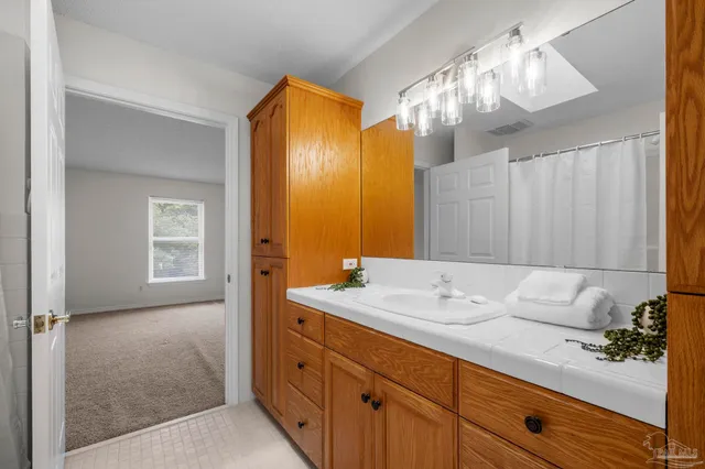 a bathroom with a granite countertop sink and a mirror