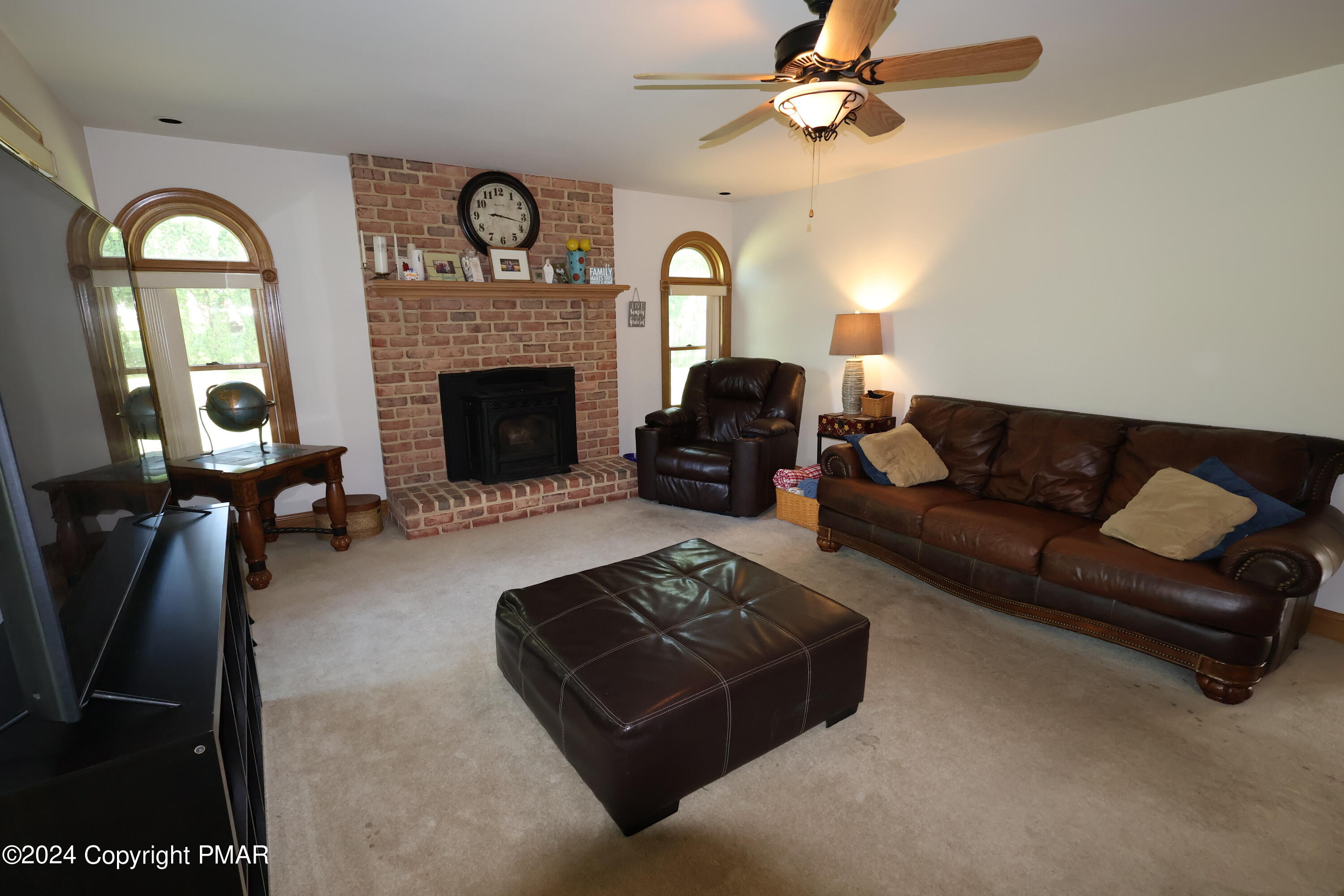 1179 Dotta Drive Pen Argyl, PA 18072 - Photo 17 of 39 a living room with furniture a fireplace and a chandelier