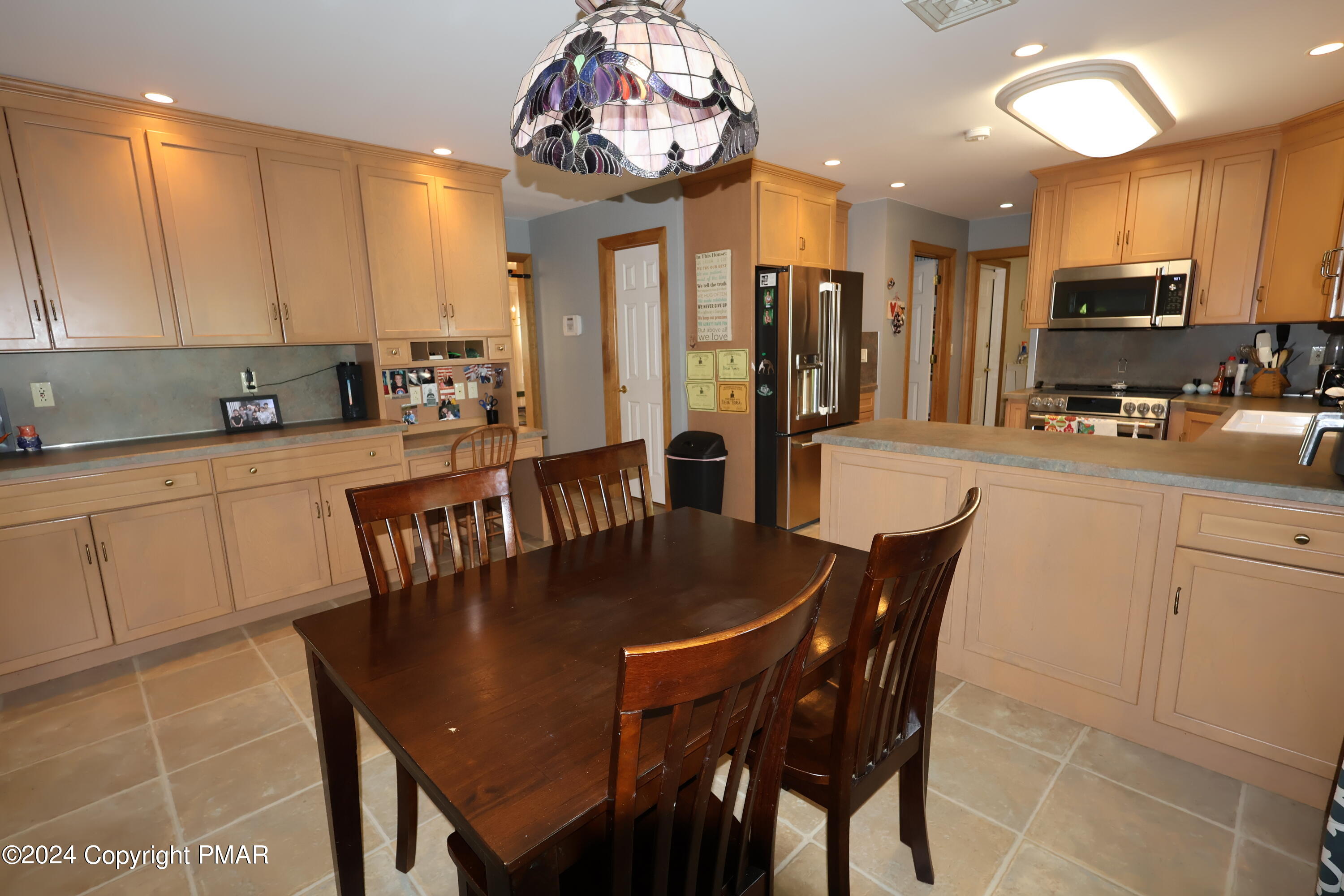 1179 Dotta Drive Pen Argyl, PA 18072 - Photo 8 of 39 a kitchen with stainless steel appliances granite countertop a dining table chairs sink refrigerator and cabinets