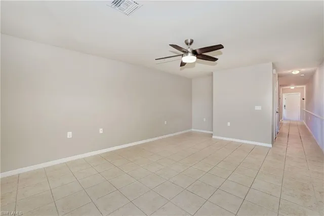 an empty room with closet and a chandelier fan