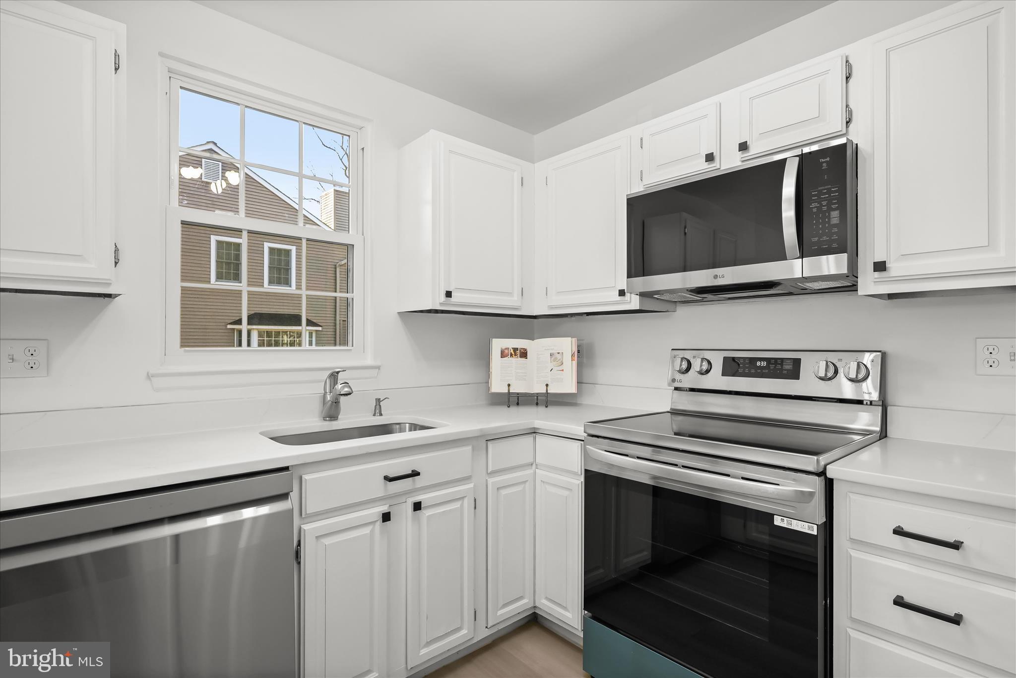 9344 Spring Water Path Jessup, MD 20794 - Photo 15 of 61 a kitchen with stainless steel appliances a stove microwave and sink