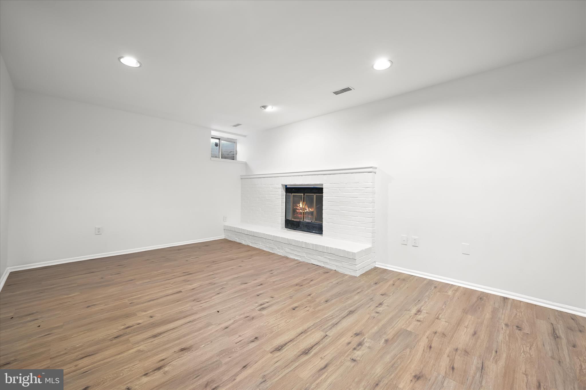 9344 Spring Water Path Jessup, MD 20794 - Photo 46 of 61 an empty room with wooden floor and fireplace