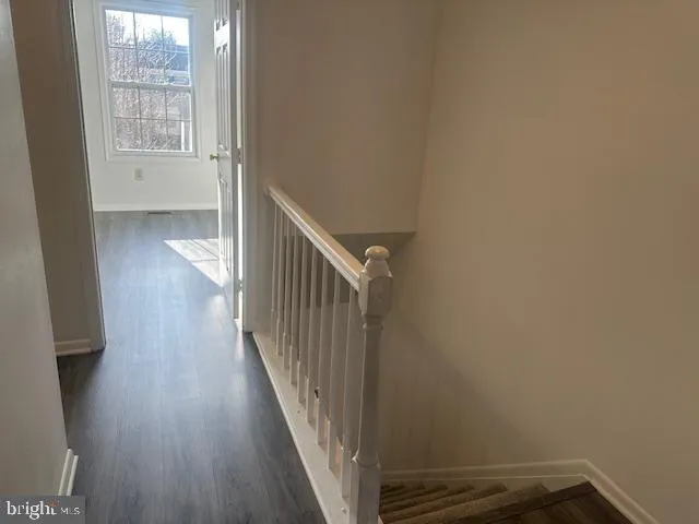 a view of a hallway with wooden floor and a window