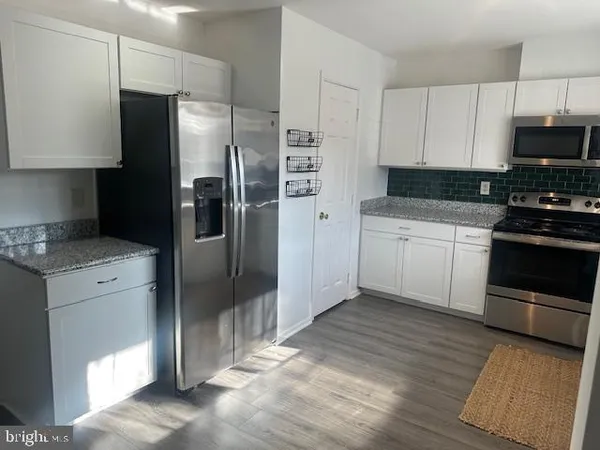 a kitchen with stainless steel appliances a refrigerator stove and microwave