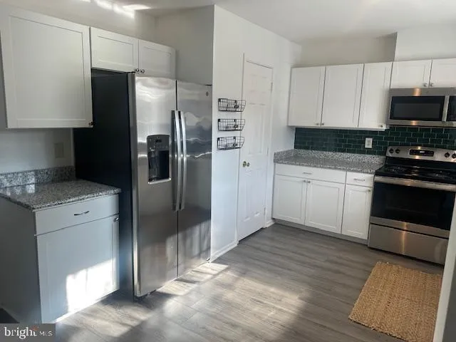 a kitchen with stainless steel appliances a refrigerator stove and microwave