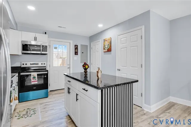 a kitchen with stainless steel appliances granite countertop a sink a stove and a microwave