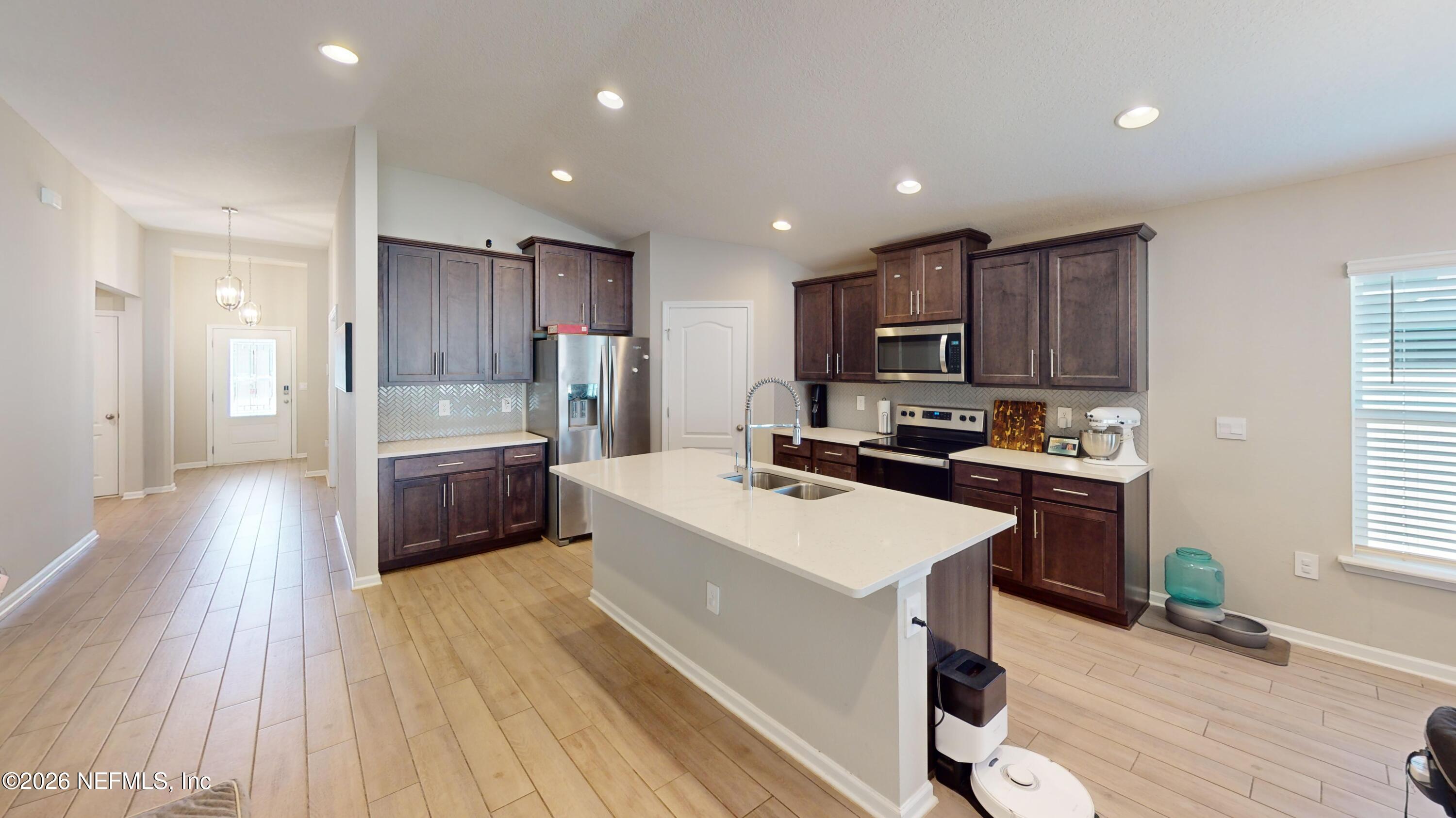 70625 Turtle Creek Yulee, FL 32097 - Photo 3 of 19 a kitchen with a sink a counter top space stainless steel appliances and a window