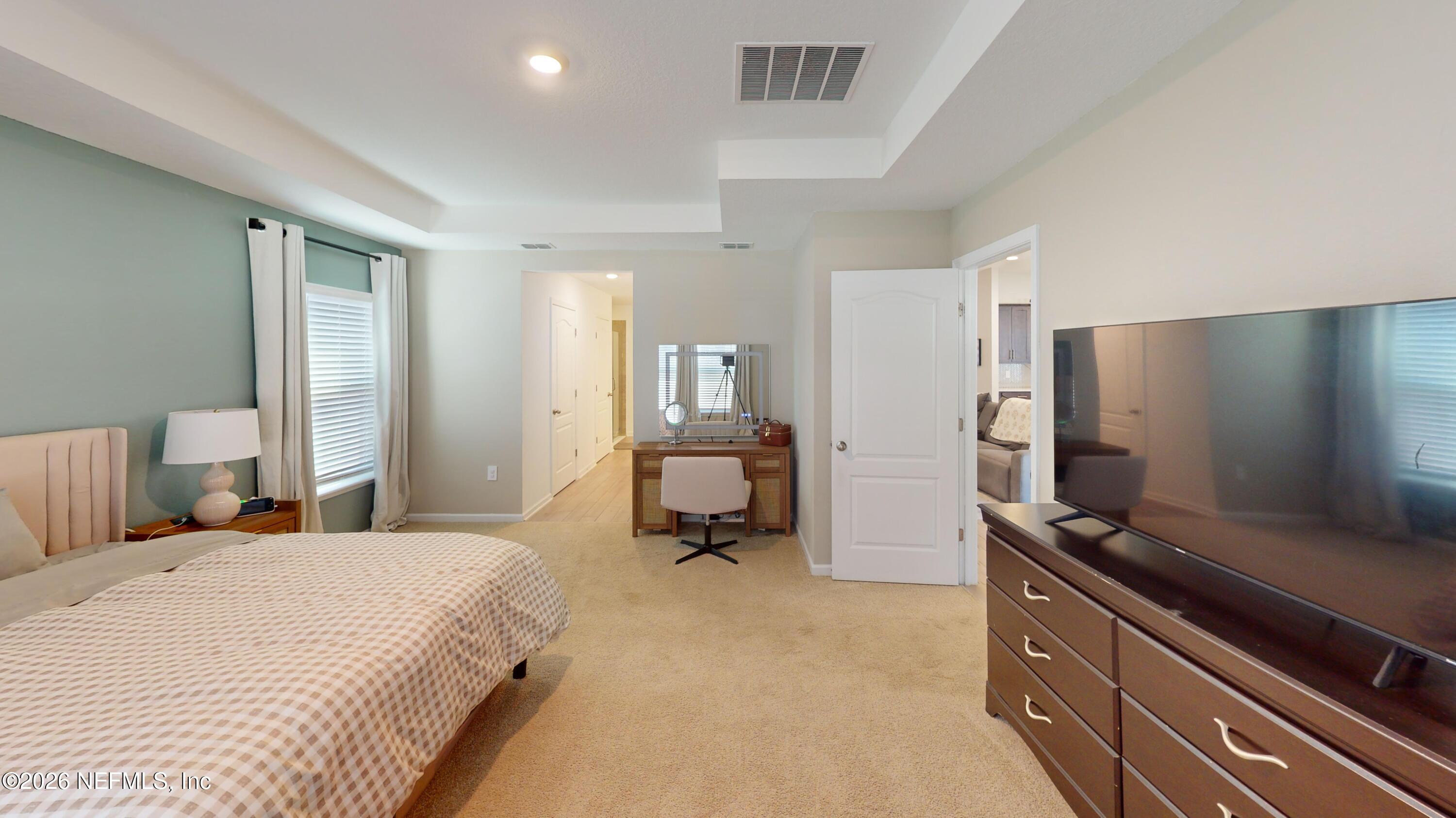 70625 Turtle Creek Yulee, FL 32097 - Photo 9 of 19 a bedroom with a bed and flat tv screen on the dresser