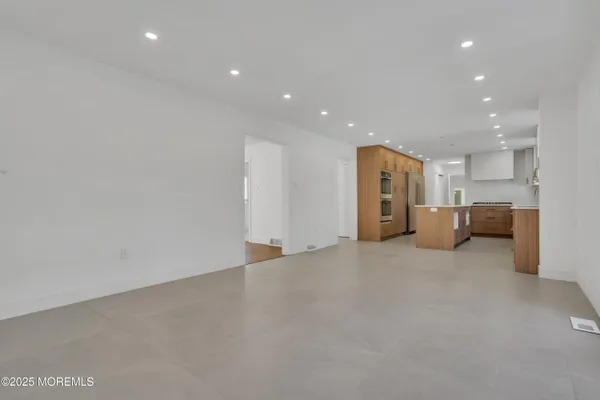 a view of a kitchen with large windows and a living room