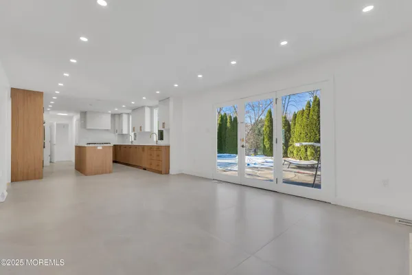 a large kitchen with stainless steel appliances granite countertop a large counter top a sink and a refrigerator