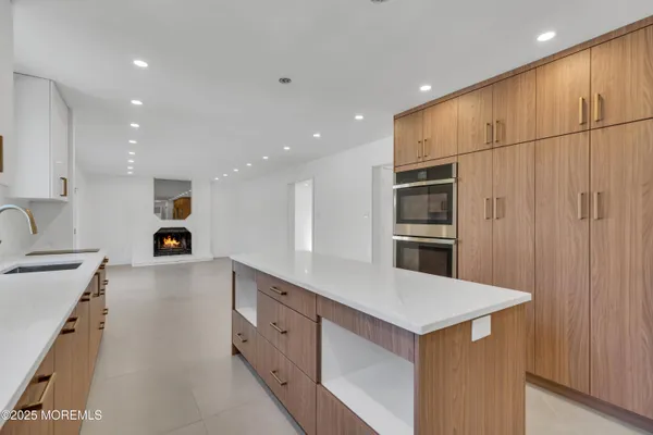 a kitchen with kitchen island a counter top space cabinets and stainless steel appliances