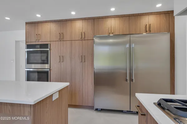 a kitchen with kitchen island a sink appliances and a cabinets