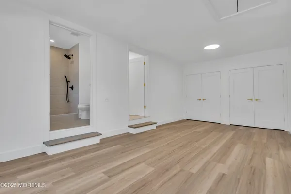 a view of an empty room with wooden floor