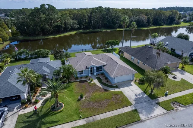 an aerial view of a house with a yard and lake view