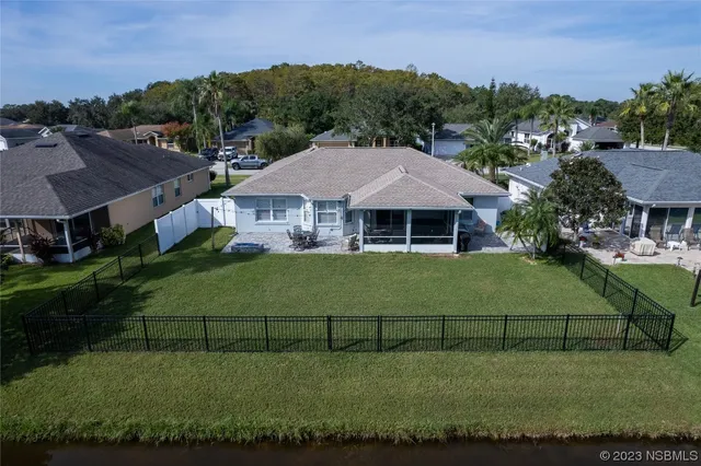 an aerial view of residential houses with outdoor space and trees