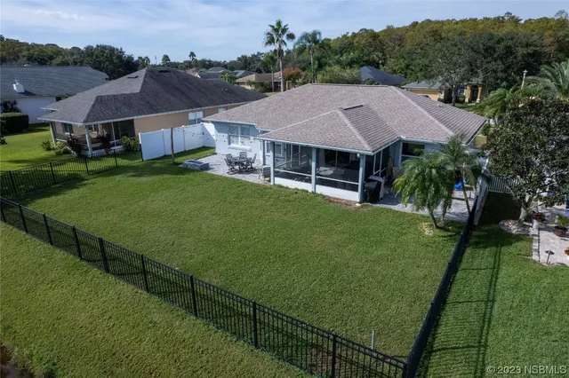 an aerial view of a house with swimming pool and outdoor seating