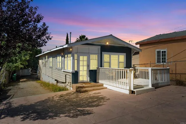 a view of a house with a small yard and wooden fence
