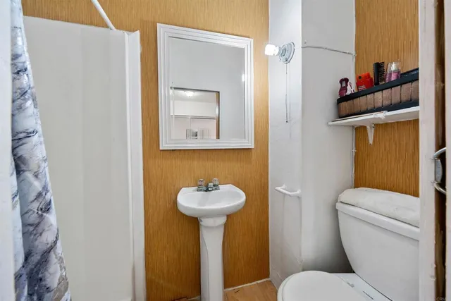 a view of a house with a wooden bench next to a road