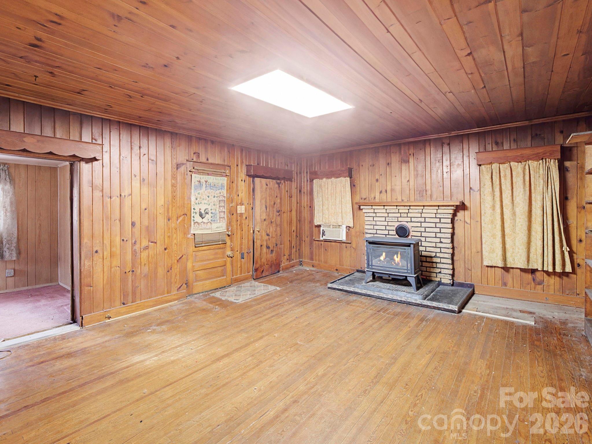 1526 Bills Creek Road Lake Lure, NC 28746 - Photo 13 of 25 a view of an empty room with a fireplace and a window