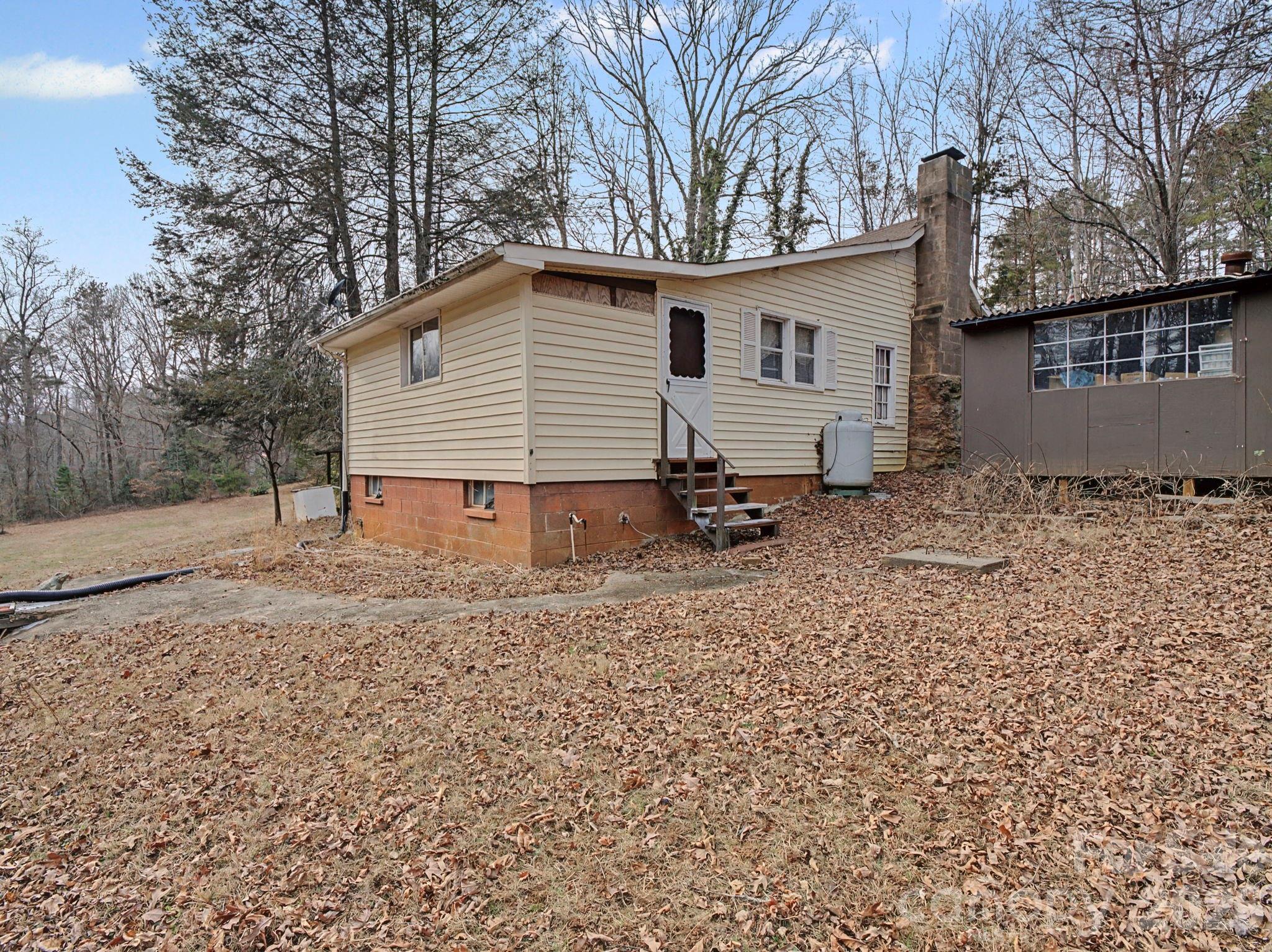1526 Bills Creek Road Lake Lure, NC 28746 - Photo 6 of 25 a backyard of a house with large trees