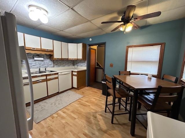718 11th Street North Virginia, MN 55792 - Photo 4 of 23 Kitchen featuring white cabinets, light countertops, tasteful backsplash, freestanding refrigerator, and light wood-type flooring