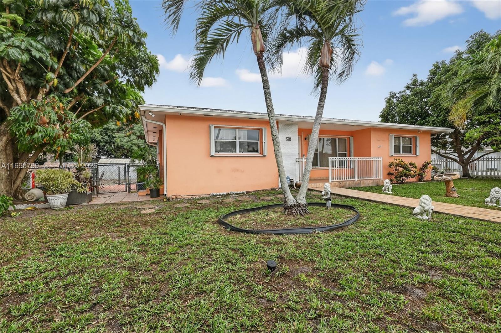 500 East 30th Street Hialeah, FL 33013 - Photo 2 of 41 a front view of a house with a garden and trees