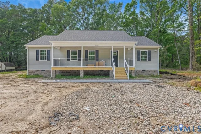 a view of a house with a yard and large trees