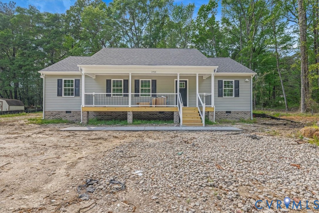 a view of a house with a yard and large trees