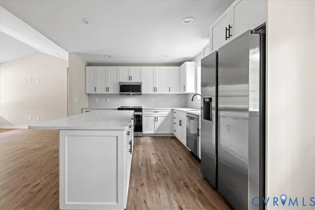 a kitchen with stainless steel appliances a refrigerator sink and microwave
