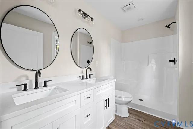 a bathroom with a double vanity sink toilet and a mirror