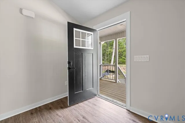 a view of a hallway with wooden floor and windows