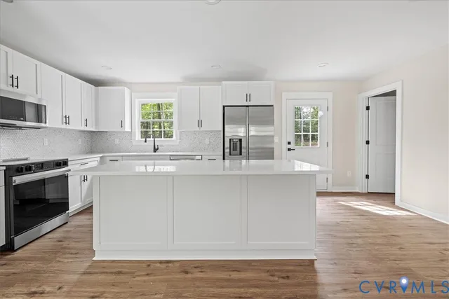 a kitchen with stainless steel appliances granite countertop a stove a sink and a microwave