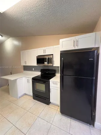 a kitchen with stainless steel appliances a stove a microwave and a refrigerator