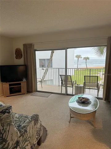 a living room with furniture a flat screen tv and a large window