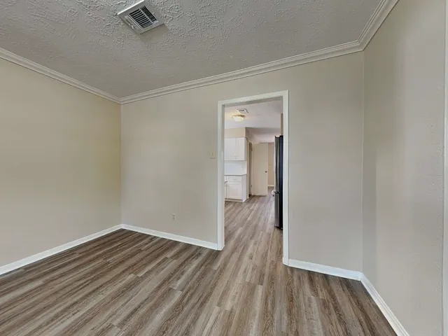 a view of a room with wooden floor and a window