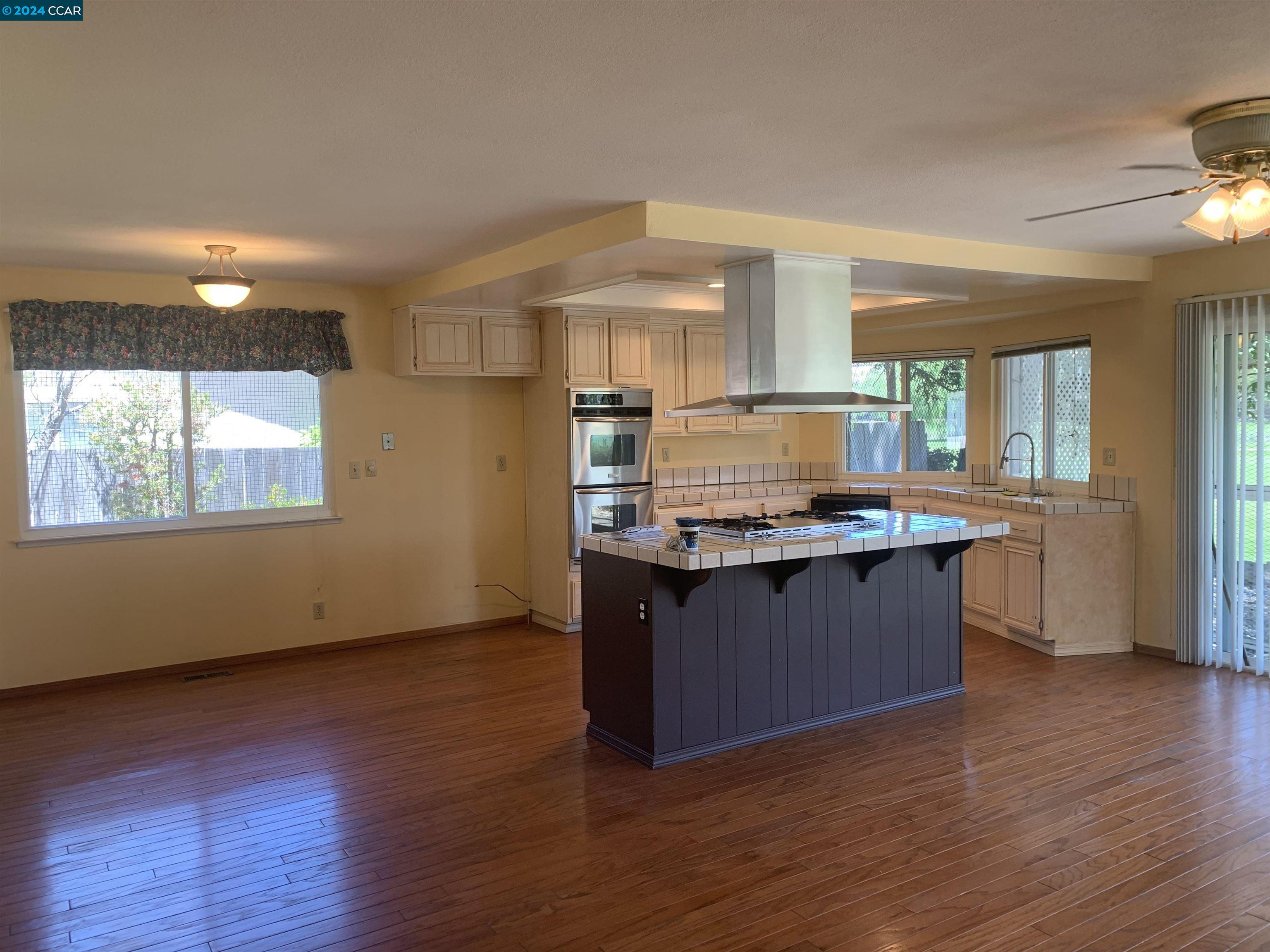 9462 Thunderbird Place San Ramon, CA 94583 - Photo 14 of 17 a kitchen with granite countertop wooden cabinets and a wooden floor