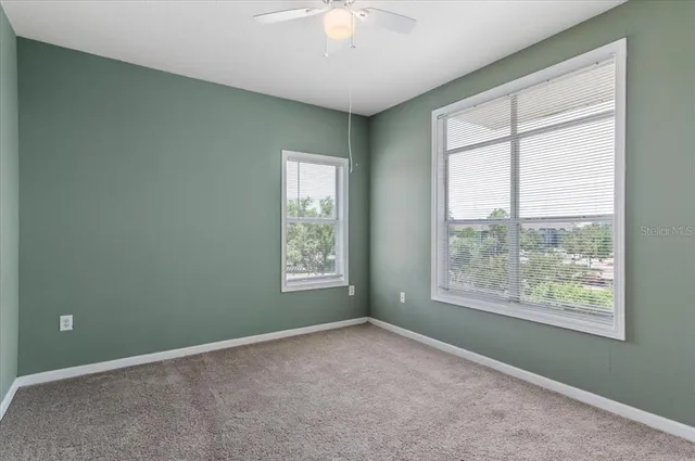 an empty room with fan and entrance