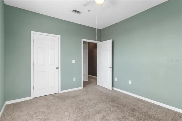 an empty room with a window and a fan