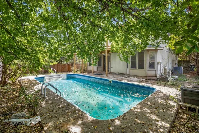 a view of a backyard with table and chairs and a large tree