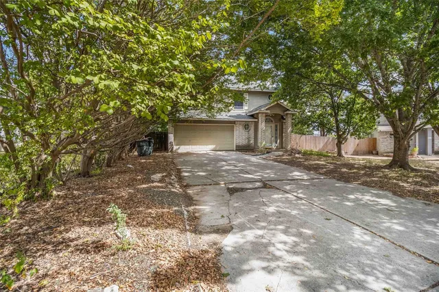 a front view of a house with a tree