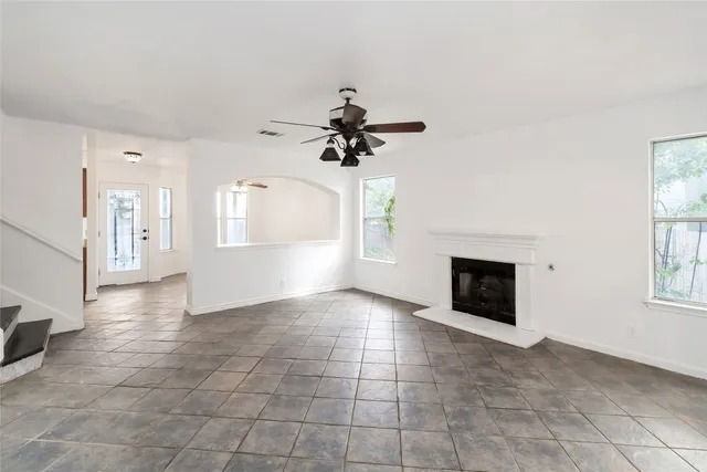 a view of an empty room with a fireplace and a window