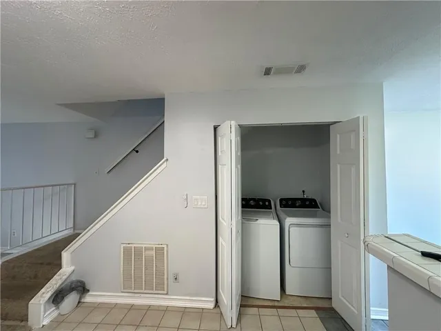 a view of a kitchen with refrigerator and white cabinets