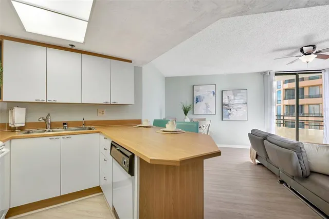 a kitchen with stainless steel appliances granite countertop a sink and dishwasher a stove top oven with wooden floor