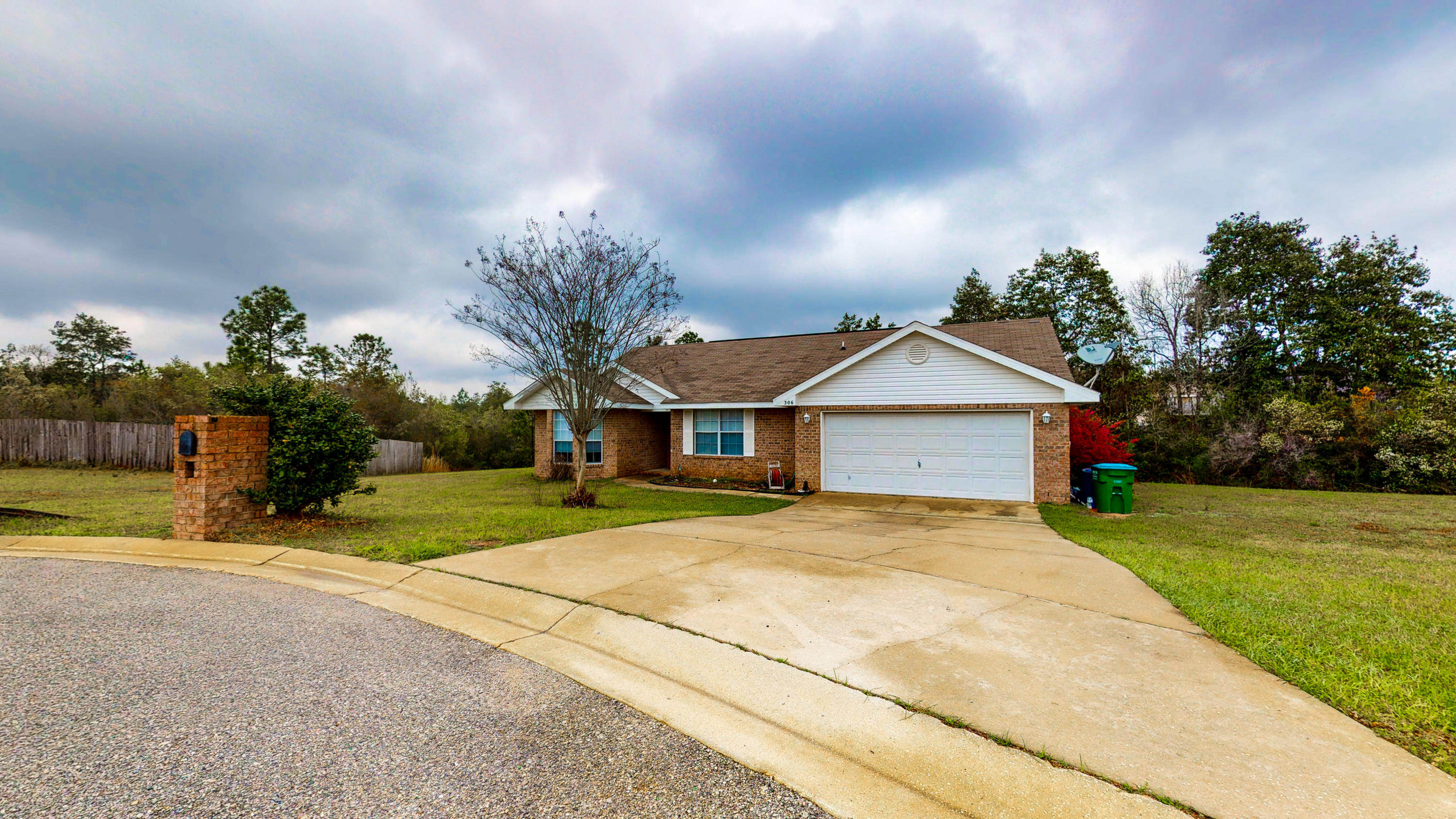 306 Shield Drive Crestview, FL 32539 - Photo 5 of 34 a yellow house with trees in front of it