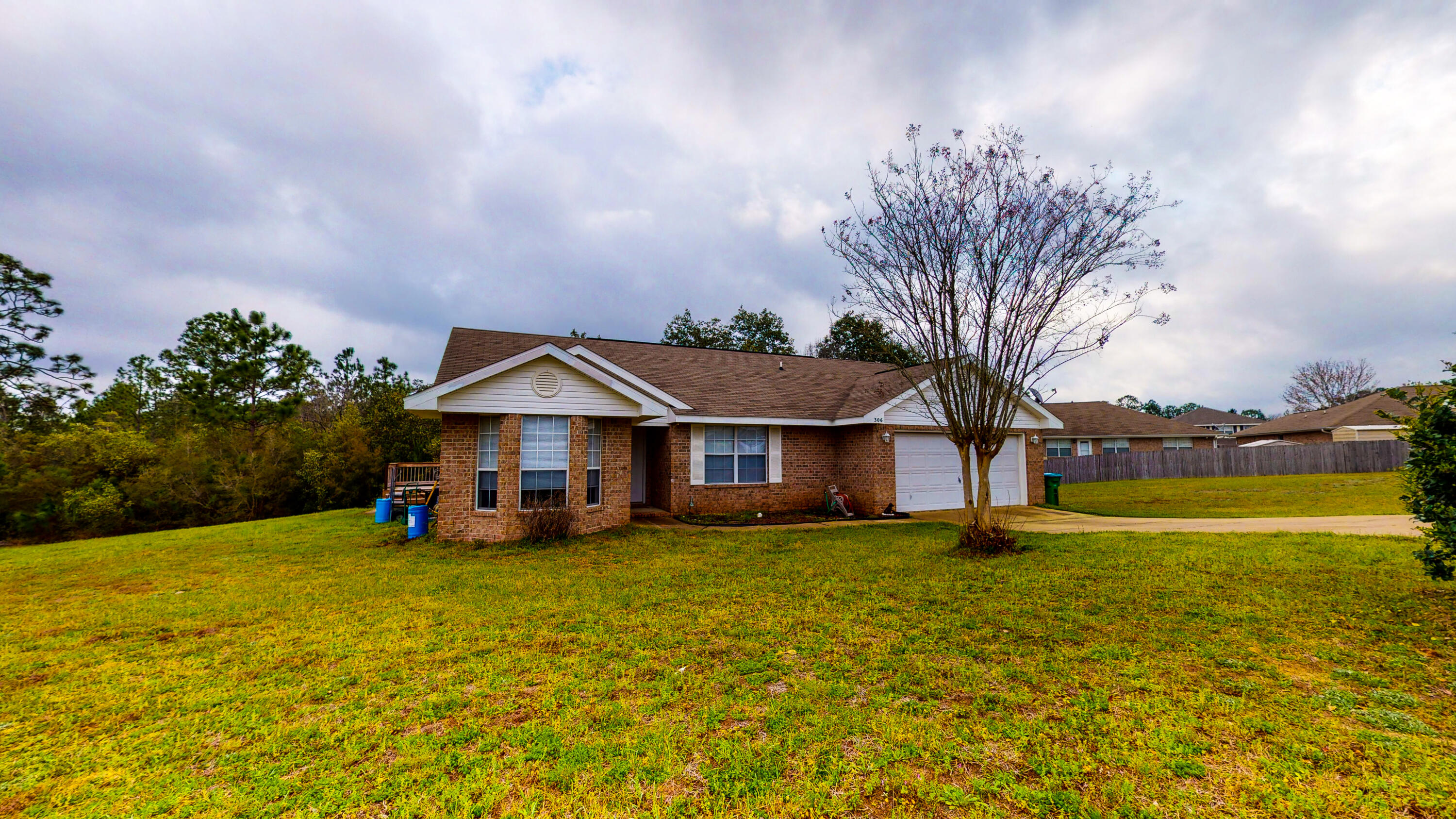 306 Shield Drive Crestview, FL 32539 - Photo 7 of 34 a view of a house with a big yard and large trees