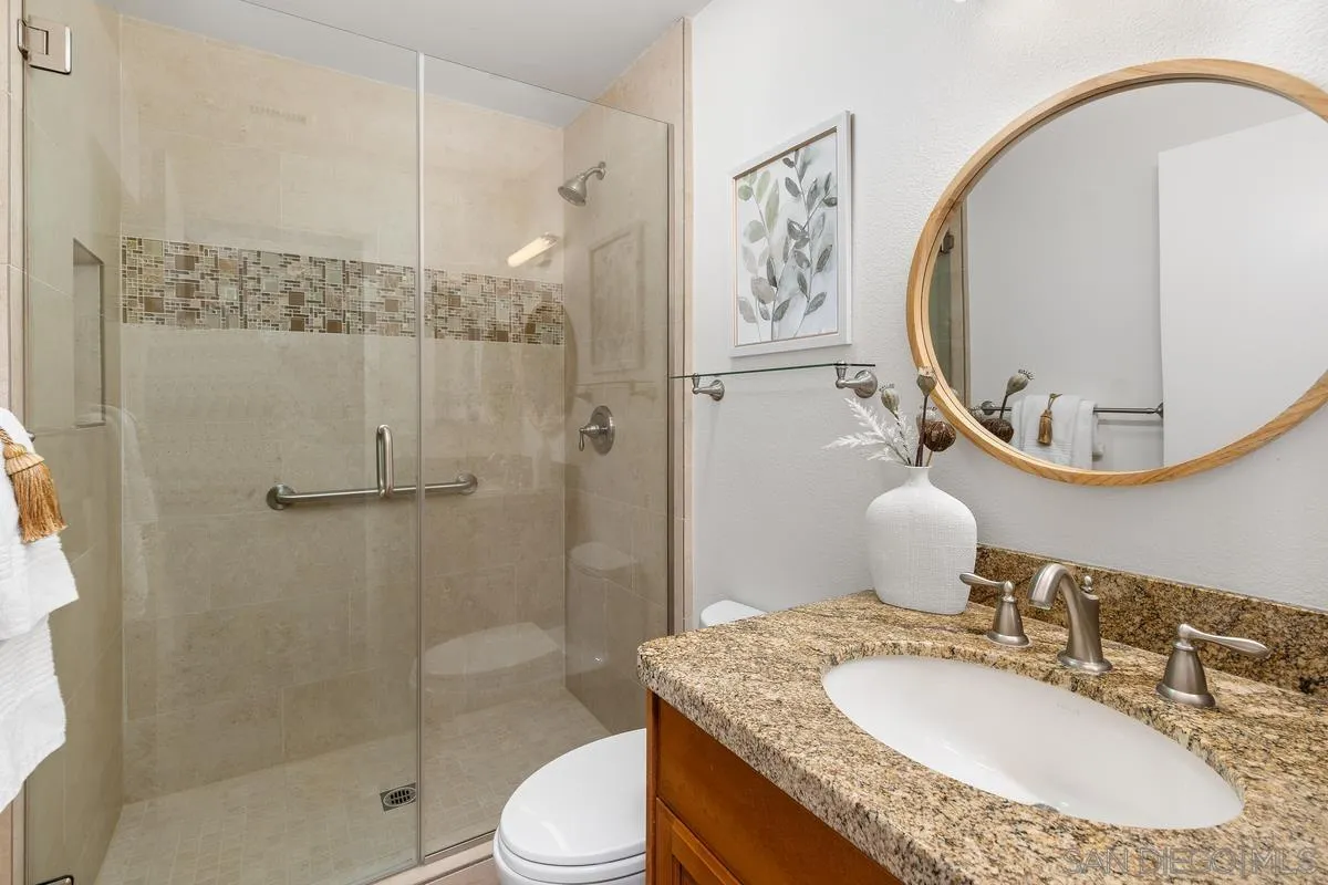 4219 Rueda Drive San Diego, CA 92124 - Photo 11 of 36 a bathroom with a granite countertop toilet a sink and a mirror