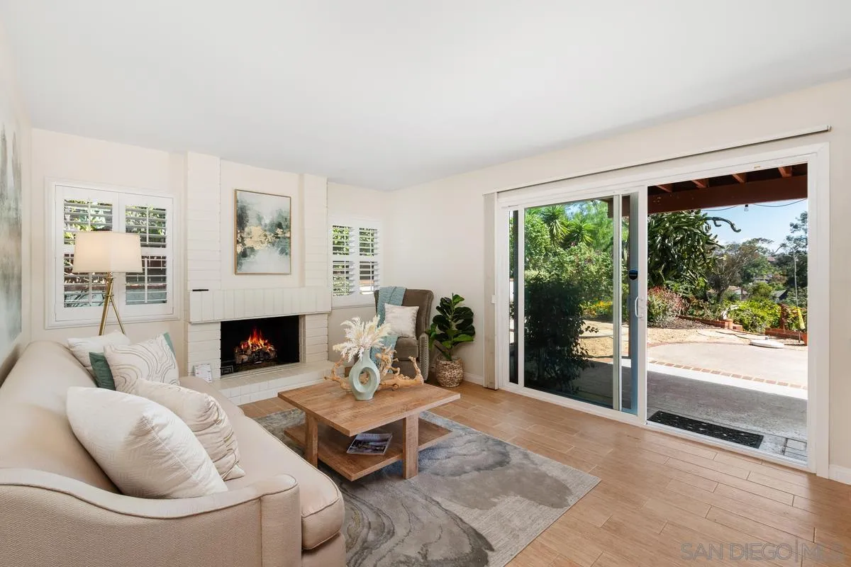 4219 Rueda Drive San Diego, CA 92124 - Photo 15 of 36 a living room with furniture a large window and a fireplace
